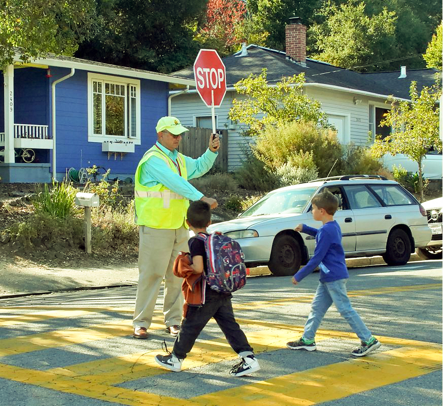 School crossing guard assists children crossing street