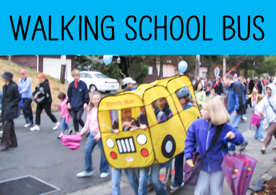 Students carrying a large toy school bus