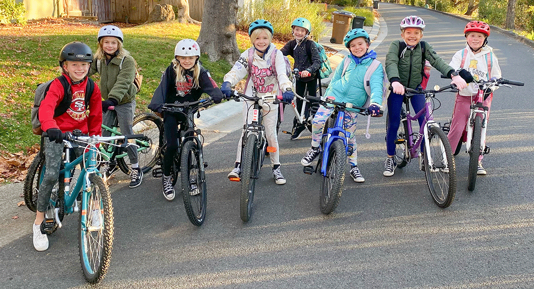 Retrato De Niña De Niño Monta En Bicicleta En Las Montañas. La Muchacha Del  Niño Llevaba Casco Y Guantes En La Bicicleta En El Montañismo. El  Montañismo Es Bueno Para La Salud.